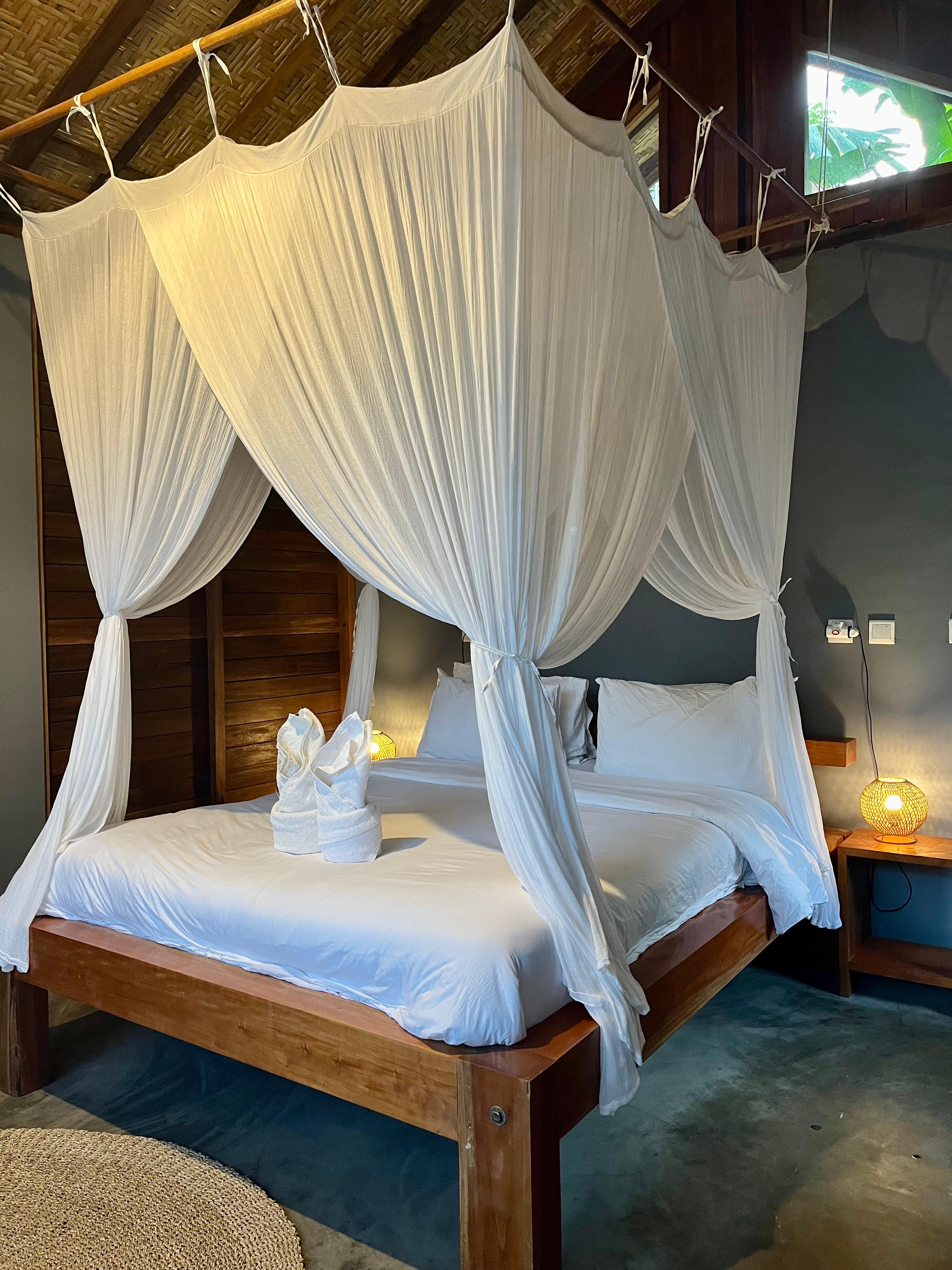 Bungalow bedroom with white mosquito-net canopy