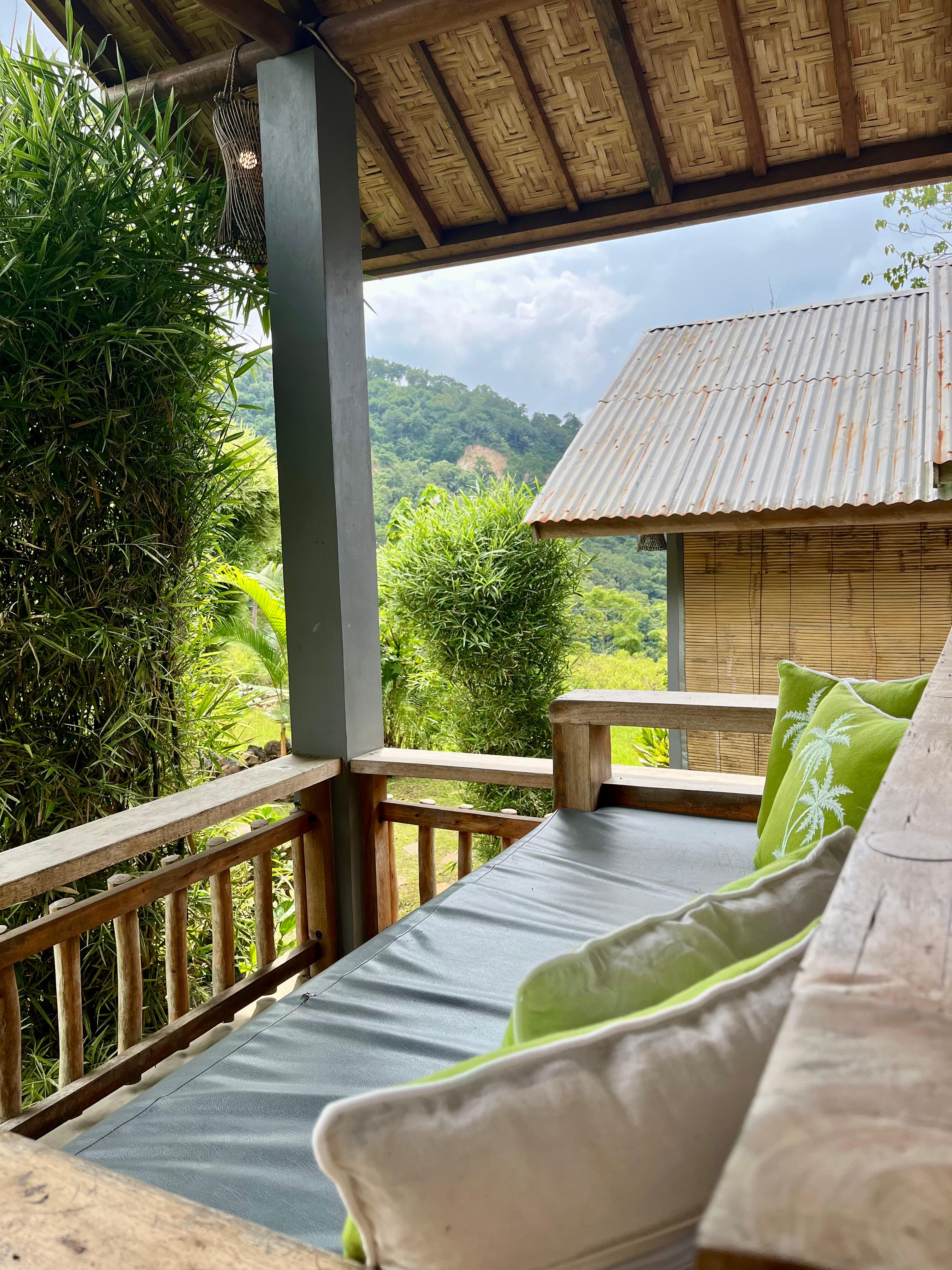 Terrace view at The Geckos Homestay overlooking the green hills of Moni, Flores