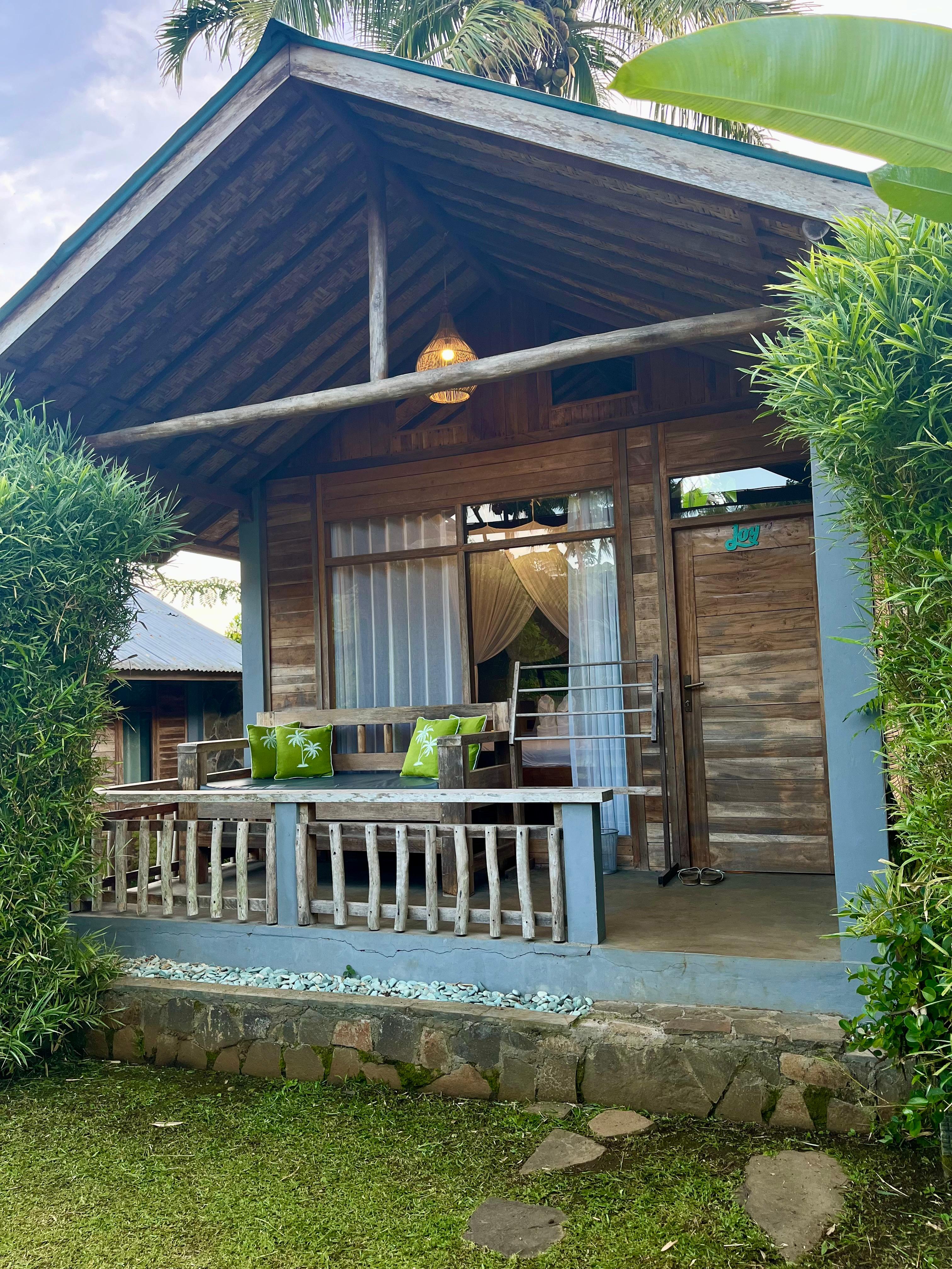 Wooden bungalow exterior with terrace at The Geckos Homestay