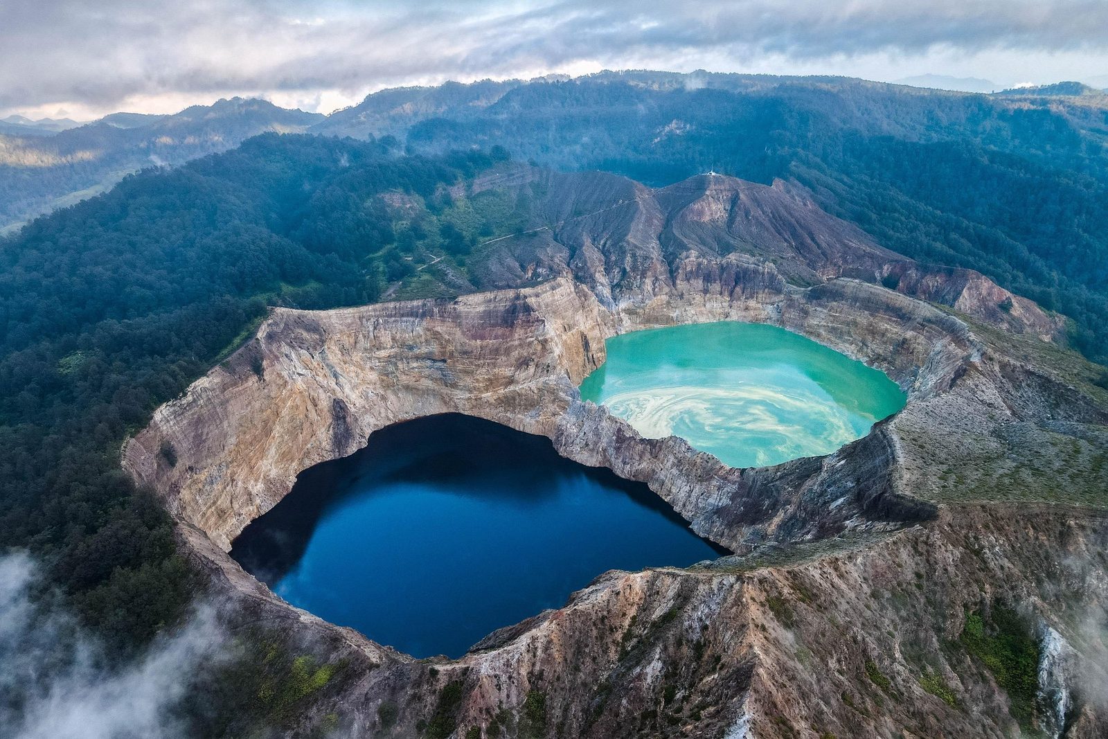 Two of Kelimutu's three crater lakes side by side, one turquoise and one deep blue